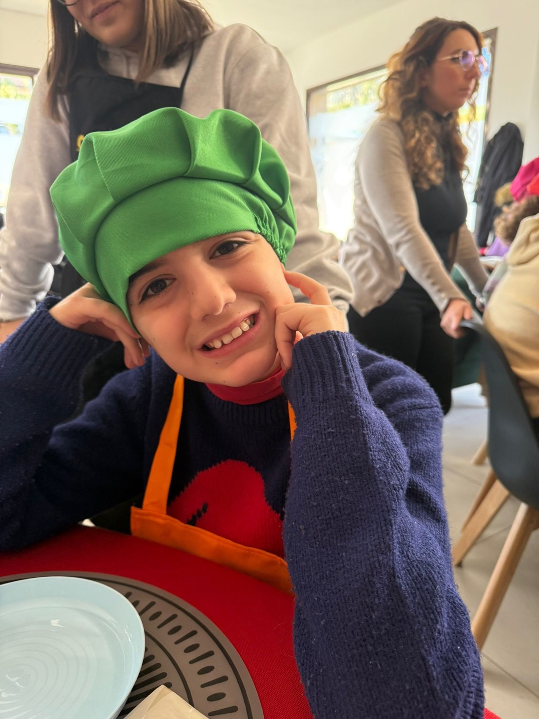 Ragazzo sorridente con grembiule da chef in cucina
