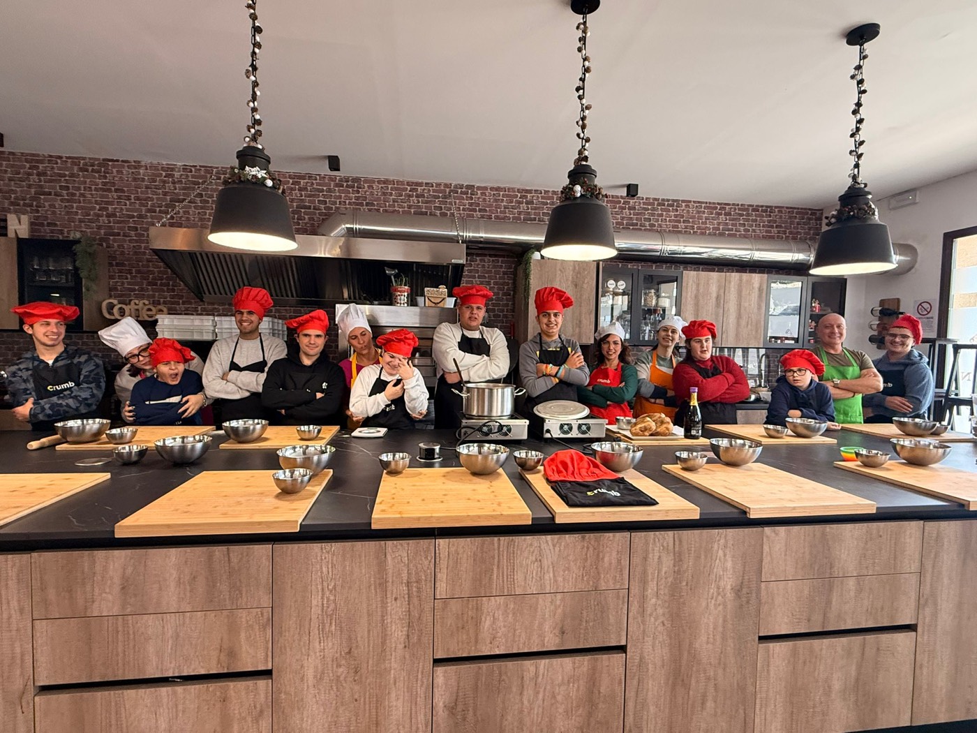 Foto di gruppo in cucina durante il laboratorio con Crumb Cooking School